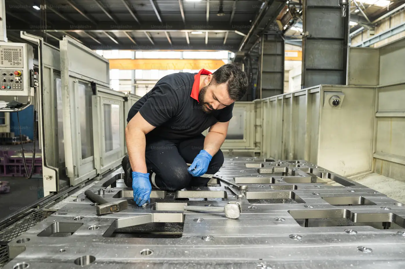Technician setting up components on a parts washer at a customer plant